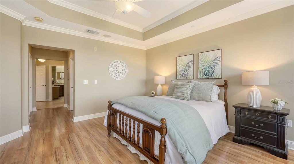 6465 Water Crest Way, Unit 404 Lakewood Ranch, FL 34202 - Photo 24 of 62 a bedroom with a bed and wooden floor