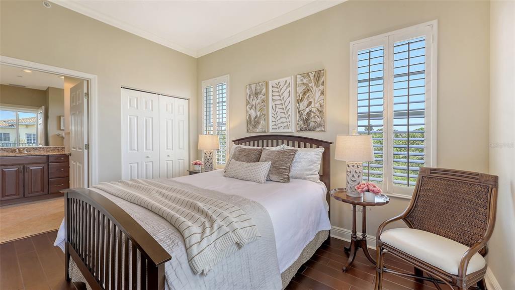 6465 Water Crest Way, Unit 404 Lakewood Ranch, FL 34202 - Photo 34 of 62 a bedroom with a bed and wooden floor