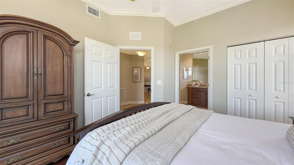 6465 Water Crest Way, Unit 404 Lakewood Ranch, FL 34202 - Photo 35 of 62 a bedroom with a bed and cabinets