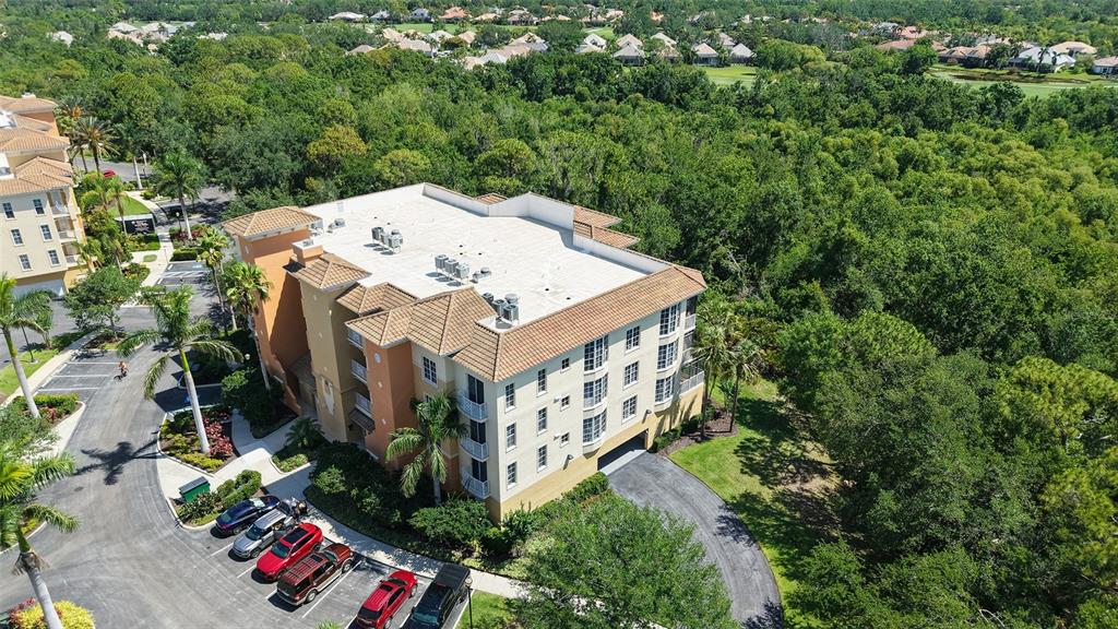 6465 Water Crest Way, Unit 404 Lakewood Ranch, FL 34202 - Photo 49 of 62 an aerial view of a house with swimming pool and large trees