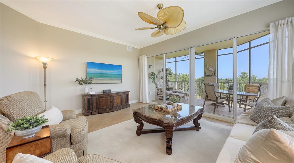 6465 Water Crest Way, Unit 404 Lakewood Ranch, FL 34202 - Photo 7 of 62 a living room with furniture and a large window