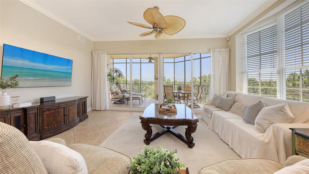 6465 Water Crest Way, Unit 404 Lakewood Ranch, FL 34202 - Photo 8 of 62 a living room with furniture and a floor to ceiling window