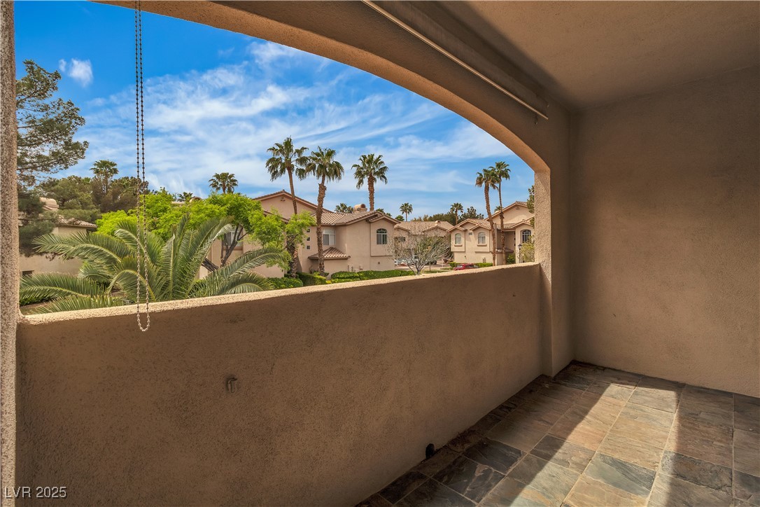 2050 West Warm Springs Road, Unit 1822 Henderson, NV 89014 - Photo 23 of 55 Slated tile Balcony with a residential view of mature palm trees and greenery.