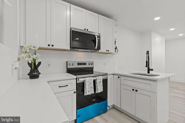 a kitchen with white cabinets and appliances