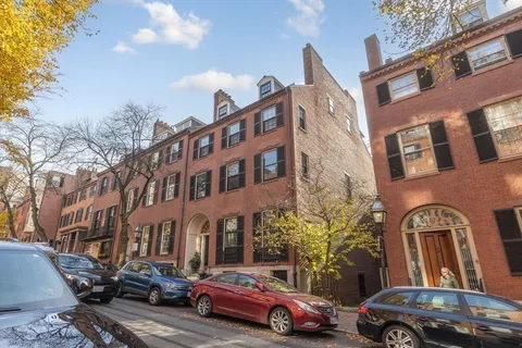 a couple of cars parked in front of a building