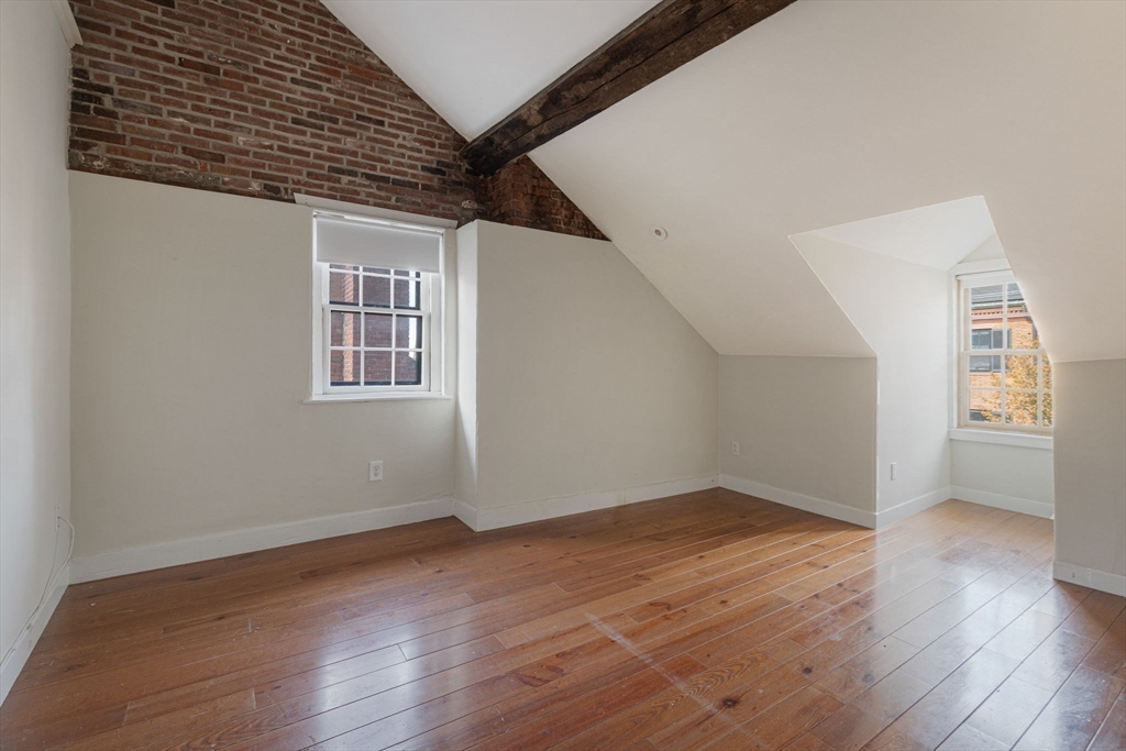 14 Chestnut Street, Unit 4 Boston, MA 02108 - Photo 4 of 12 an empty room with wooden floor and windows