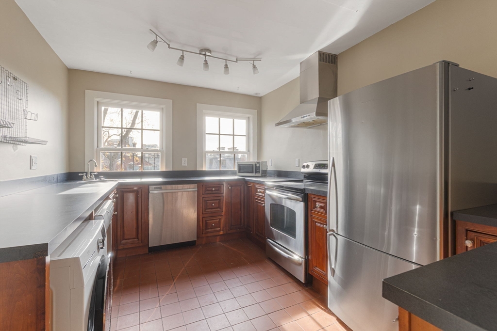 14 Chestnut Street, Unit 4 Boston, MA 02108 - Photo 7 of 12 a kitchen with granite countertop a refrigerator sink stove and cabinets