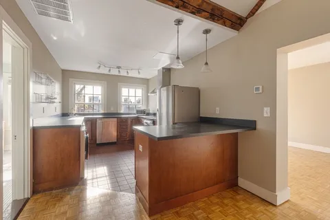 a view of a kitchen with refrigerator and windows