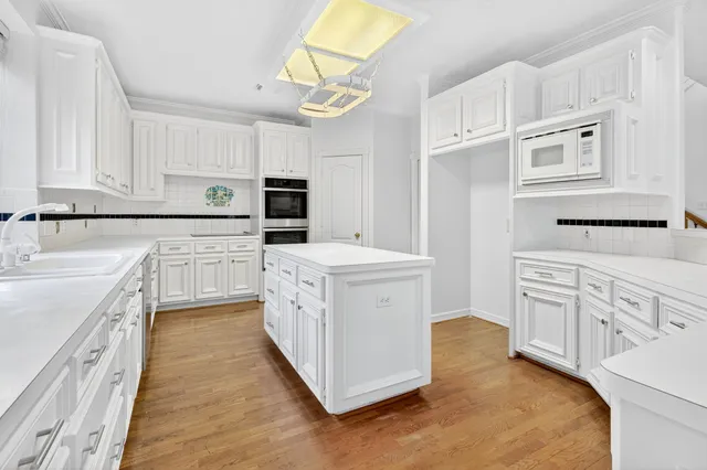 a kitchen with white cabinets and white appliances