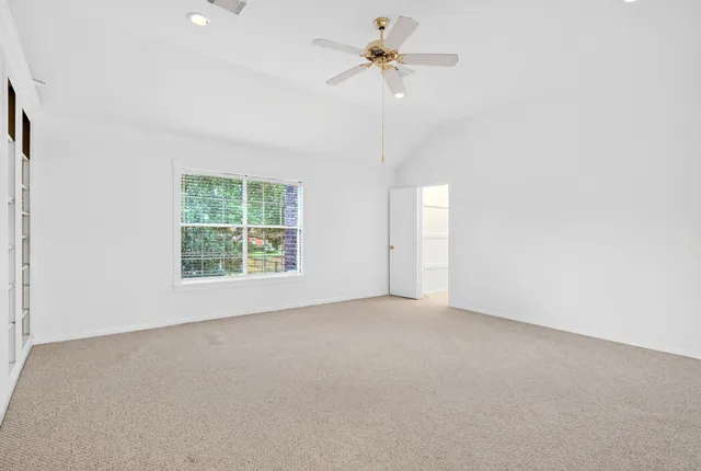 an empty room with a window and a fan