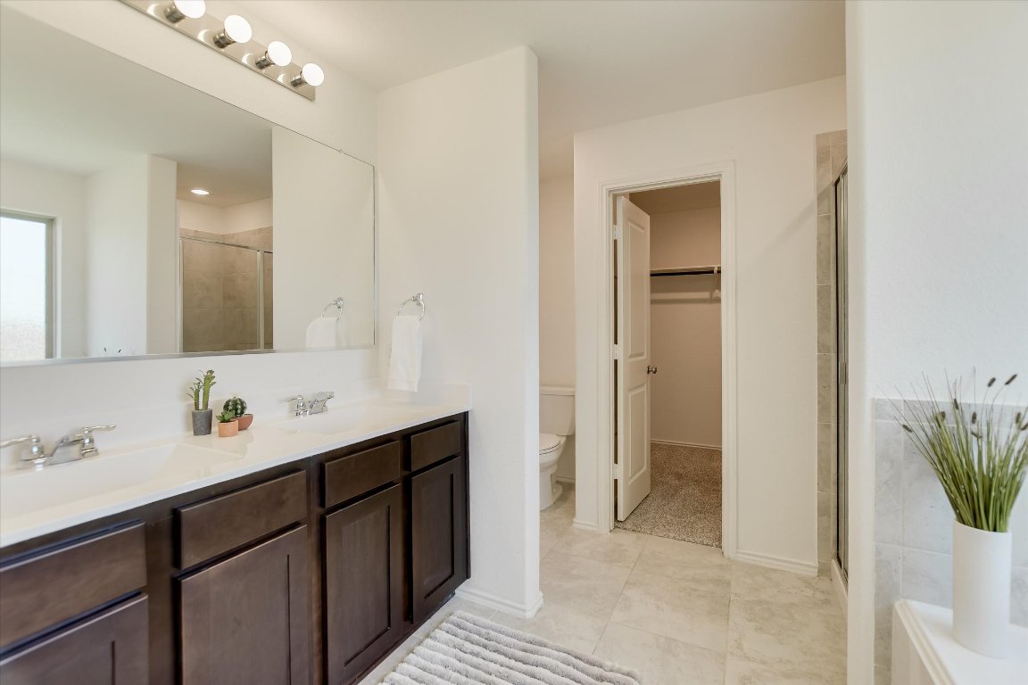 561 Greatest Gift Way Jarrell, TX 76537 - Photo 15 of 32 The primary bath is designed for two: a double vanity, spa bath and walk-in shower, with a large closet.