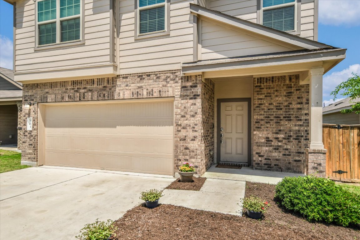 561 Greatest Gift Way Jarrell, TX 76537 - Photo 3 of 32 View of exterior entry with brick siding, a garage, and driveway