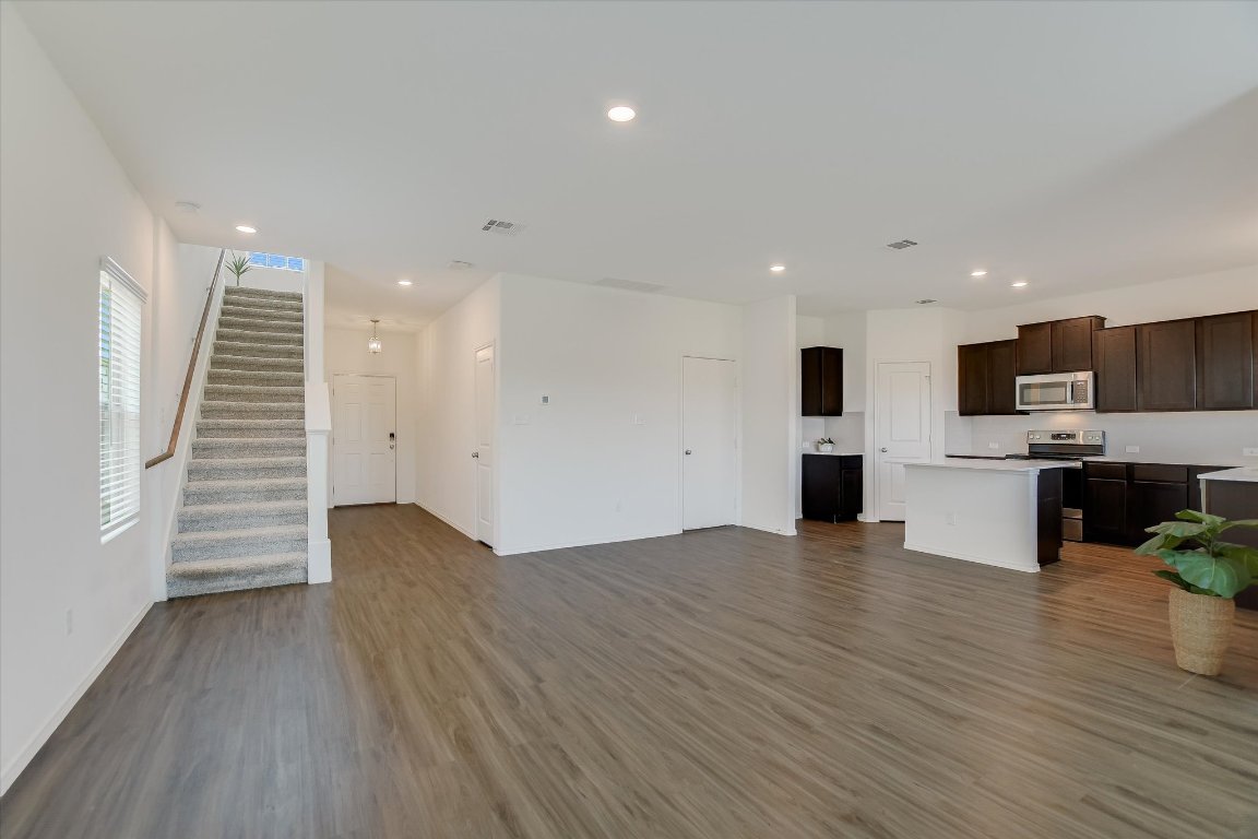 561 Greatest Gift Way Jarrell, TX 76537 - Photo 6 of 32 Unfurnished living room with wood finished floors, stairs, recessed lighting, and baseboards