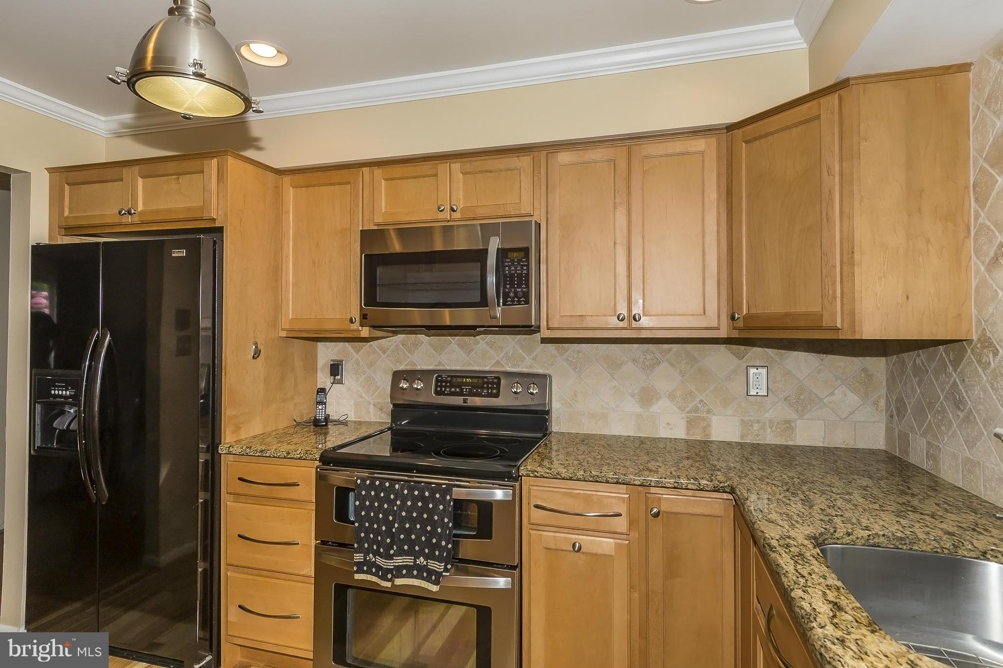 1747 Tacoma Road Edgewater, MD 21037 - Photo 7 of 19 a kitchen with granite countertop a refrigerator stove and microwave