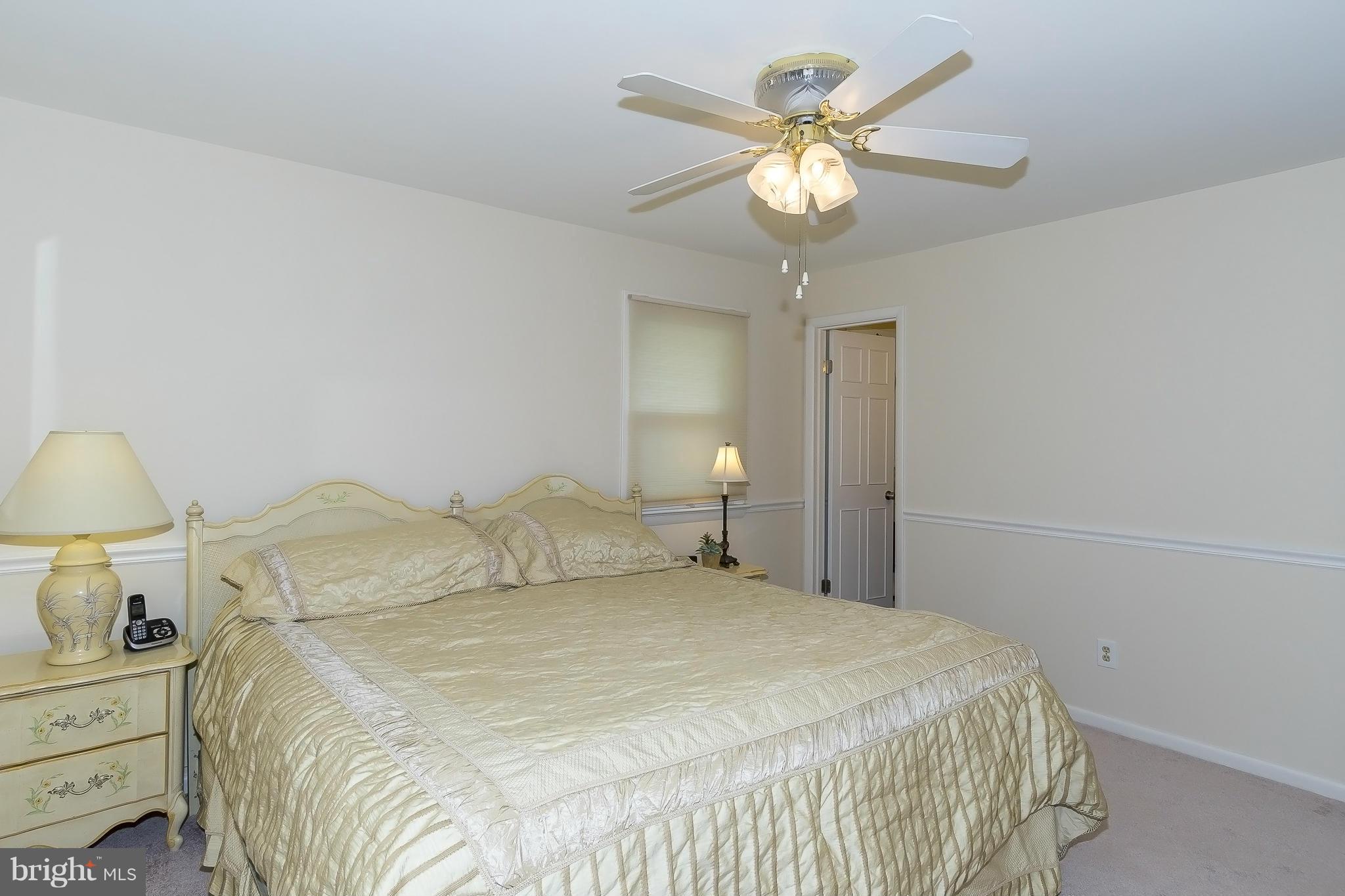 1747 Tacoma Road Edgewater, MD 21037 - Photo 10 of 19 a bedroom with a bed and a chandelier