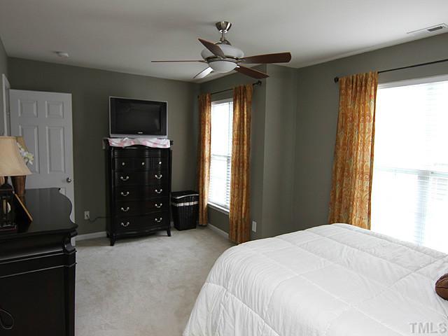 9712 Layla Avenue Raleigh, NC 27617 - Photo 15 of 25 a bedroom with a bed and a flat tv screen on dresser
