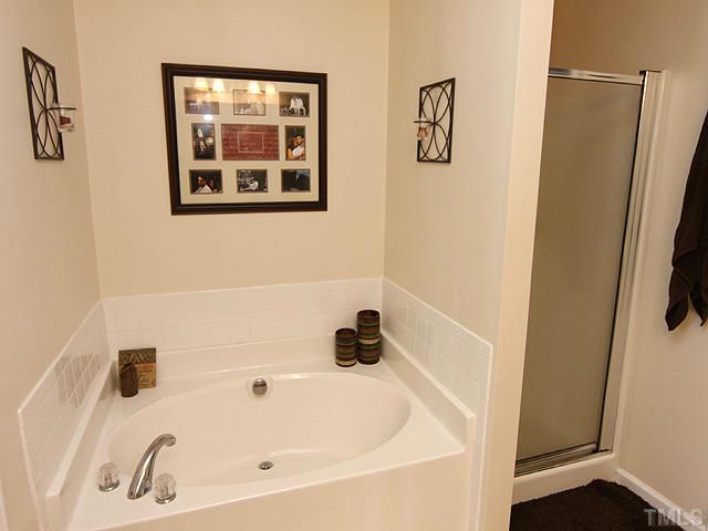 9712 Layla Avenue Raleigh, NC 27617 - Photo 17 of 25 a bathroom with a white tub and shower