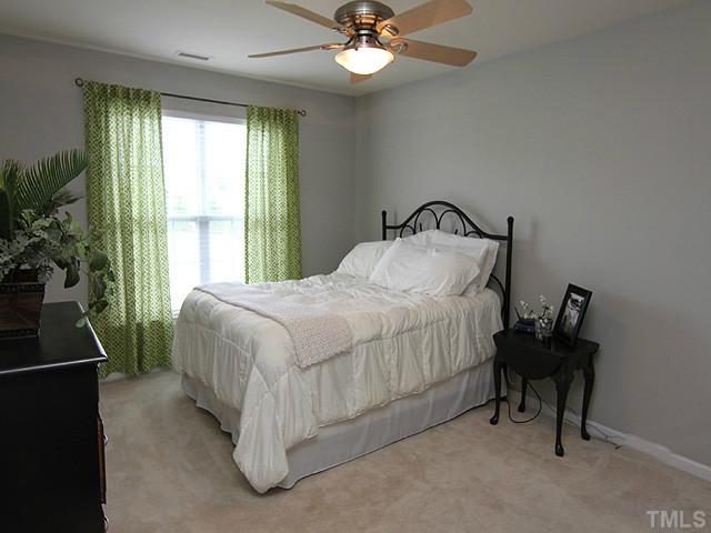 9712 Layla Avenue Raleigh, NC 27617 - Photo 18 of 25 a bedroom with a bed and a chandelier