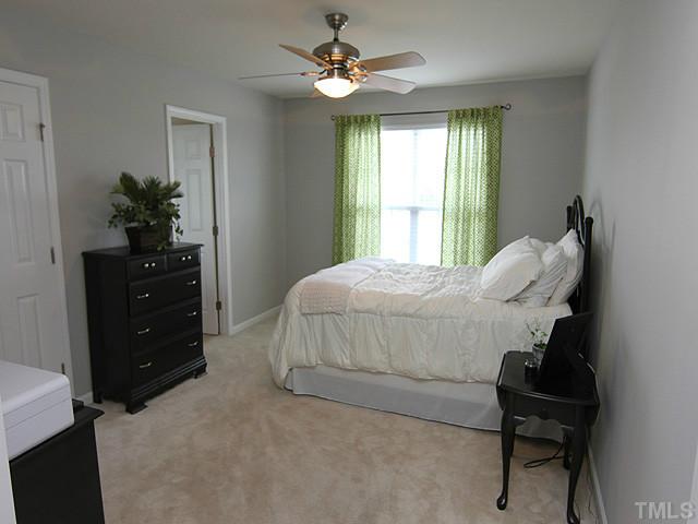 9712 Layla Avenue Raleigh, NC 27617 - Photo 19 of 25 a bedroom with a bed and a potted plant