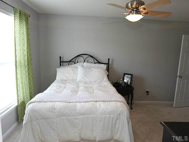 9712 Layla Avenue Raleigh, NC 27617 - Photo 20 of 25 a bedroom with a bed and a chandelier