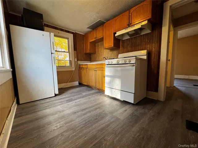 a view of a kitchen with wooden floor and electronic appliances