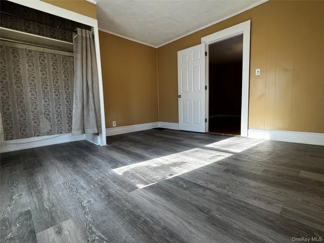 an empty room with wooden floor and closet