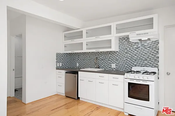 a kitchen with granite countertop white cabinets and black appliances