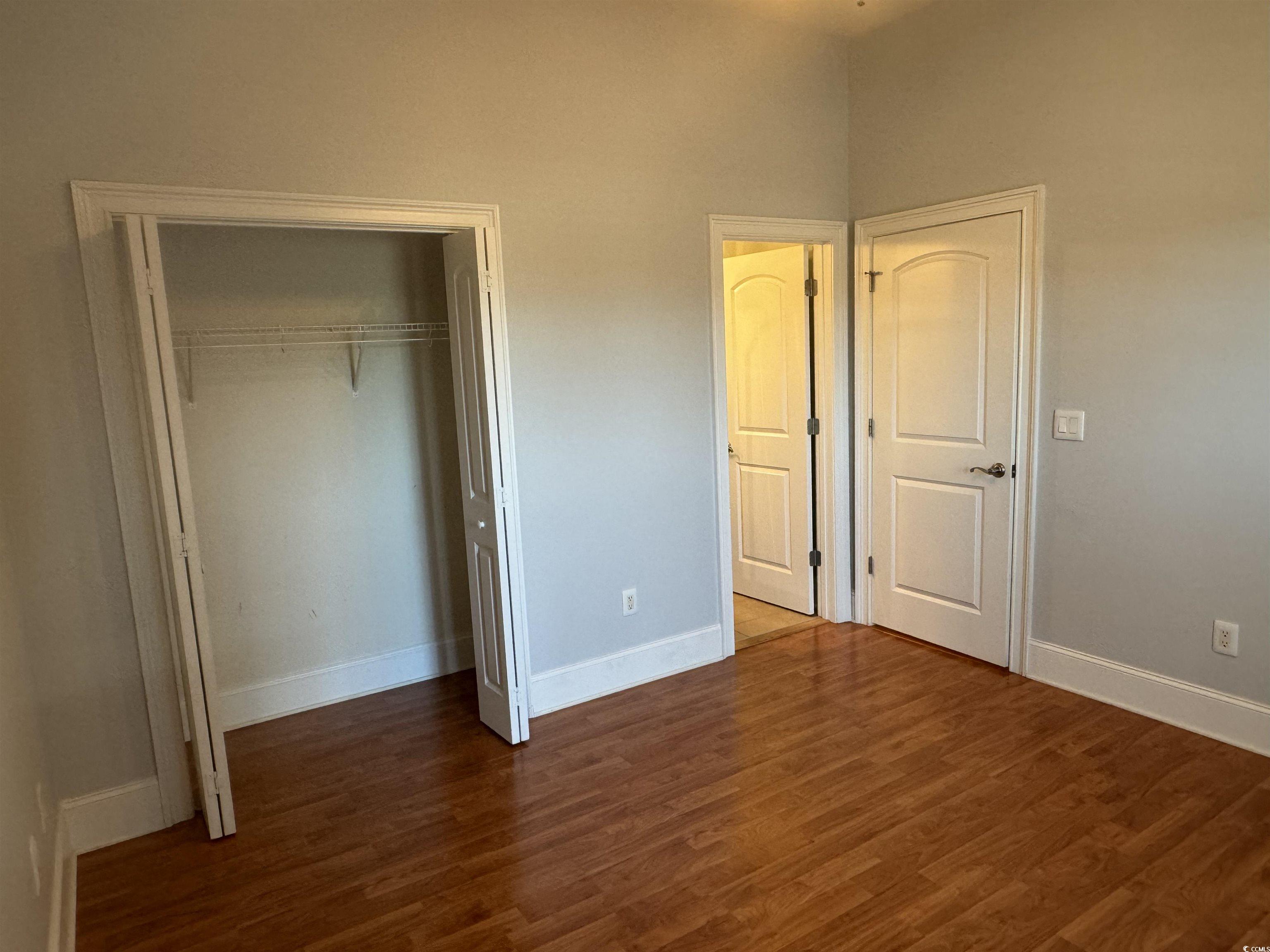 249 Venice Way, Unit 3105 Myrtle Beach, SC 29577 - Photo 21 of 40 Unfurnished bedroom with dark hardwood / wood-style floors and a closet