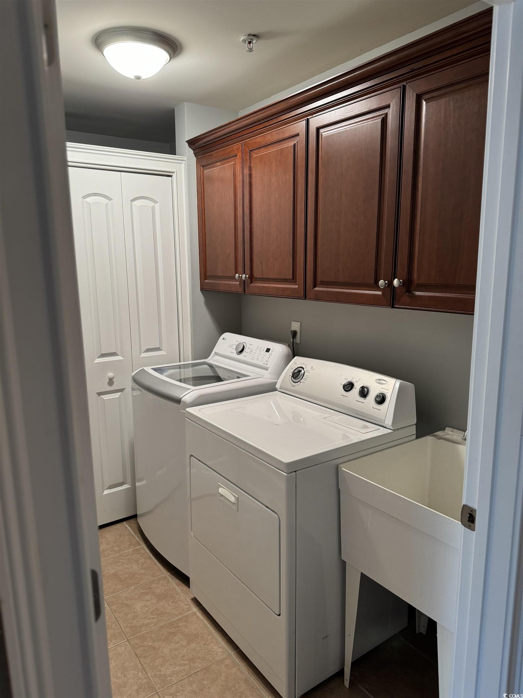 249 Venice Way, Unit 3105 Myrtle Beach, SC 29577 - Photo 24 of 40 Washroom with washer and clothes dryer, light tile patterned floors, cabinets, and sink