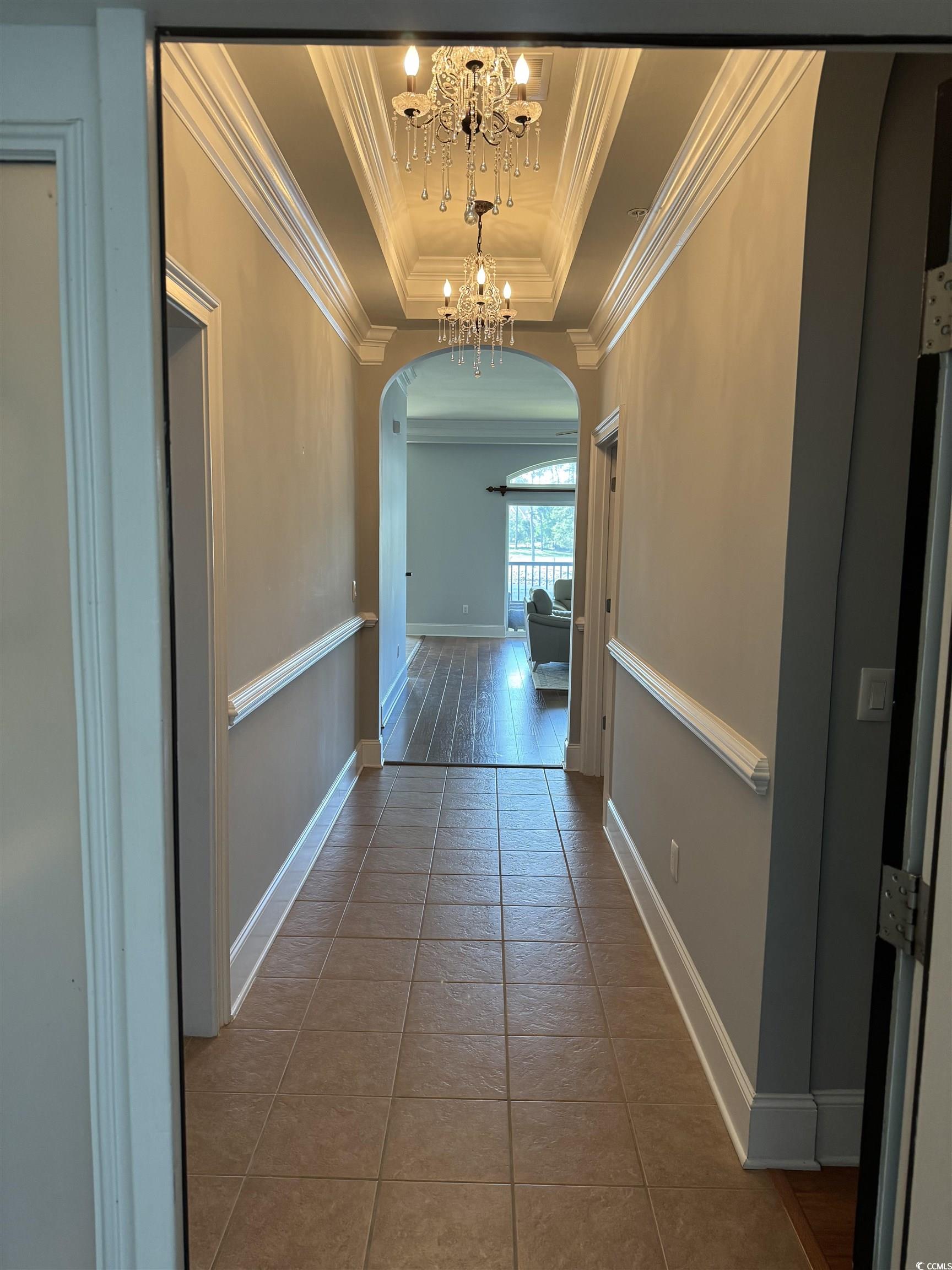 249 Venice Way, Unit 3105 Myrtle Beach, SC 29577 - Photo 25 of 40 Hallway with tile patterned flooring, a notable chandelier, a raised ceiling, and crown molding