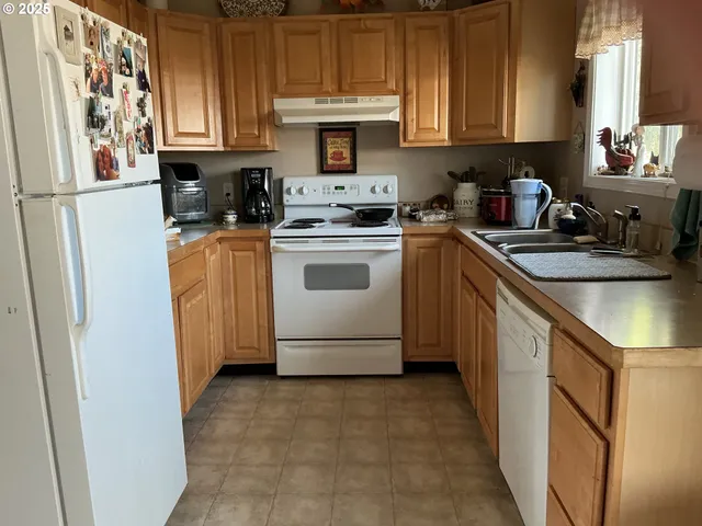 a kitchen with stainless steel appliances granite countertop a refrigerator sink and stove