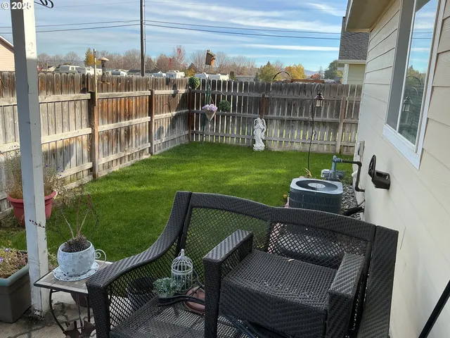 a view of a chairs and table in patio with swimming pool