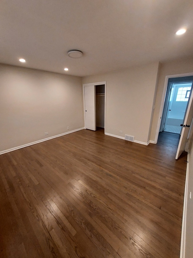 1001 North Dee Road, Unit A Park Ridge, IL 60068 - Photo 4 of 13 an empty room with wooden floor and windows