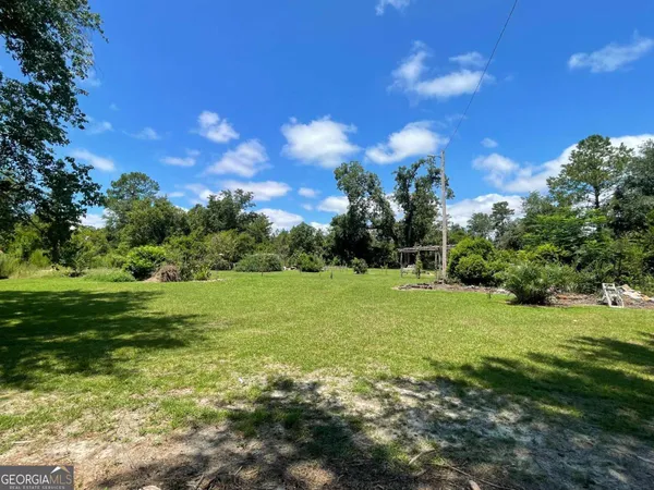 a view of a field with a tree in the background