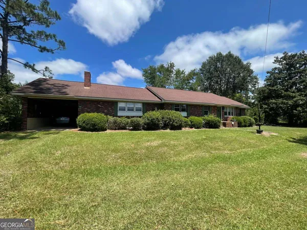 a view of a house with backyard and garden