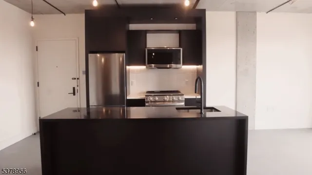 a kitchen with kitchen island a counter top space and stainless steel appliances