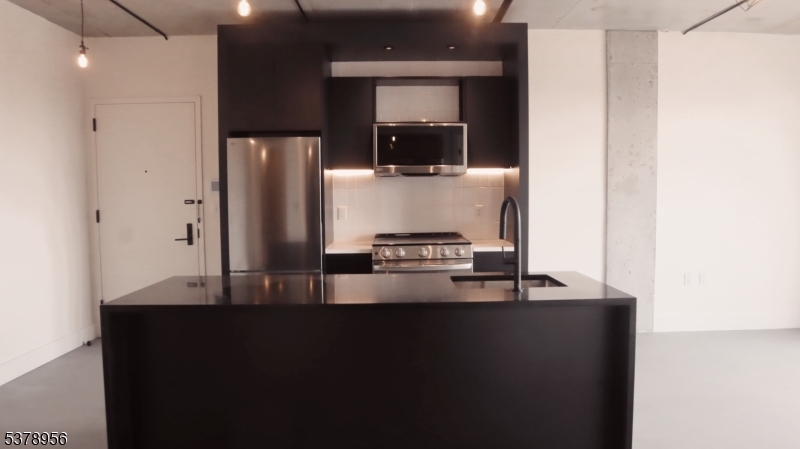 59 McWhorter Street, Unit 405 Newark, NJ 07105 - Photo 1 of 9 a kitchen with kitchen island a counter top space and stainless steel appliances