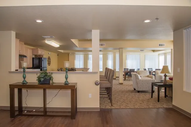 a living room with furniture a flat screen tv and kitchen view