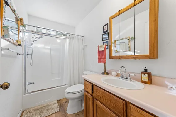 a bathroom with a granite countertop sink mirror vanity and toilet