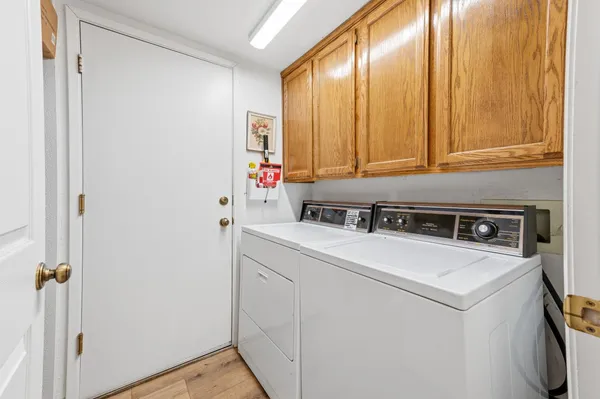 a view of washer and dryer with bathroom in the background