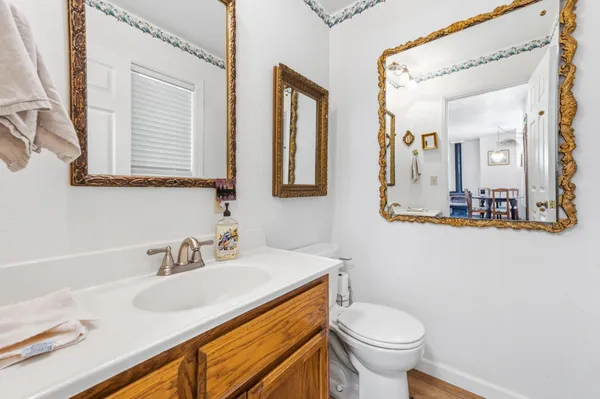 a bathroom with a granite countertop toilet sink and mirror