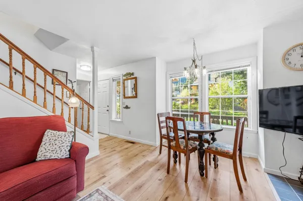 a dining room with furniture a chandelier and wooden floor