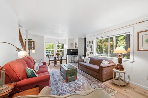 a living room with furniture wooden floor and a large window