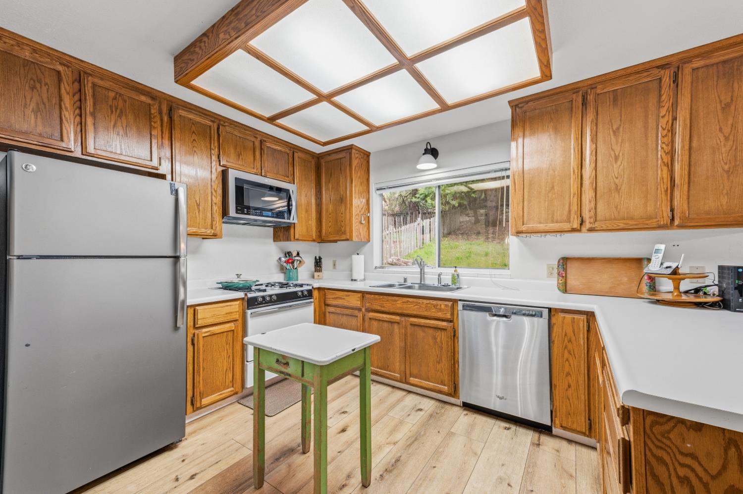 21 Spring Street Sierra City, CA 96125 - Photo 6 of 30 a kitchen with stainless steel appliances granite countertop a refrigerator a stove top oven a sink dishwasher and white cabinets with wooden floor
