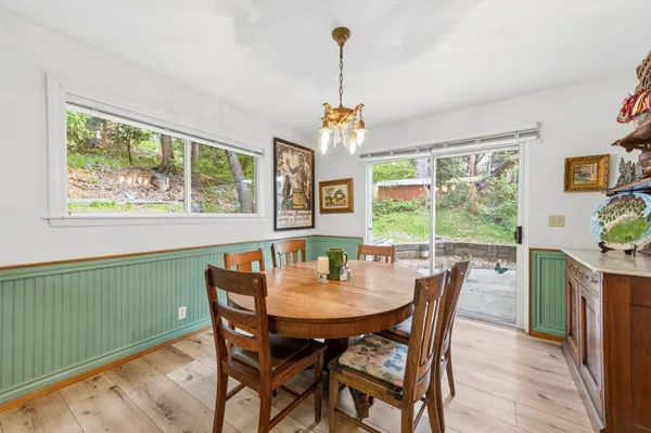 a dining room with furniture a chandelier and wooden floor