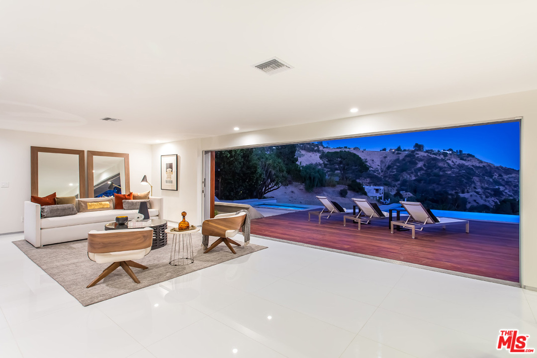 7524 Devista Drive Los Angeles, CA 90046 - Photo 46 of 54 a living room with furniture a flat screen tv and a floor to ceiling window