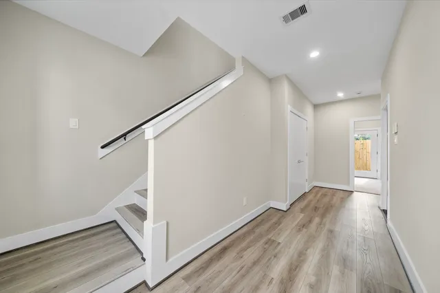 a view of hallway with stairs and wooden floor