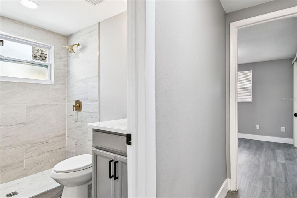 3800 Darlington Road Holiday, FL 34691 - Photo 21 of 36 a white toilet sitting next to a bathroom sink and a mirror