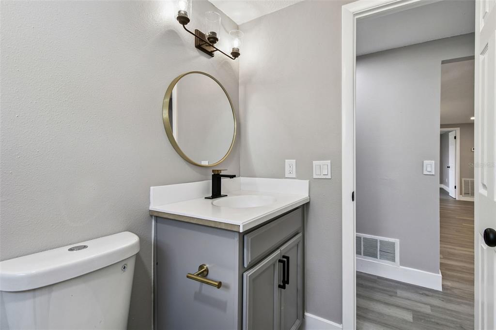 3800 Darlington Road Holiday, FL 34691 - Photo 22 of 36 a bathroom with a granite countertop toilet sink and mirror