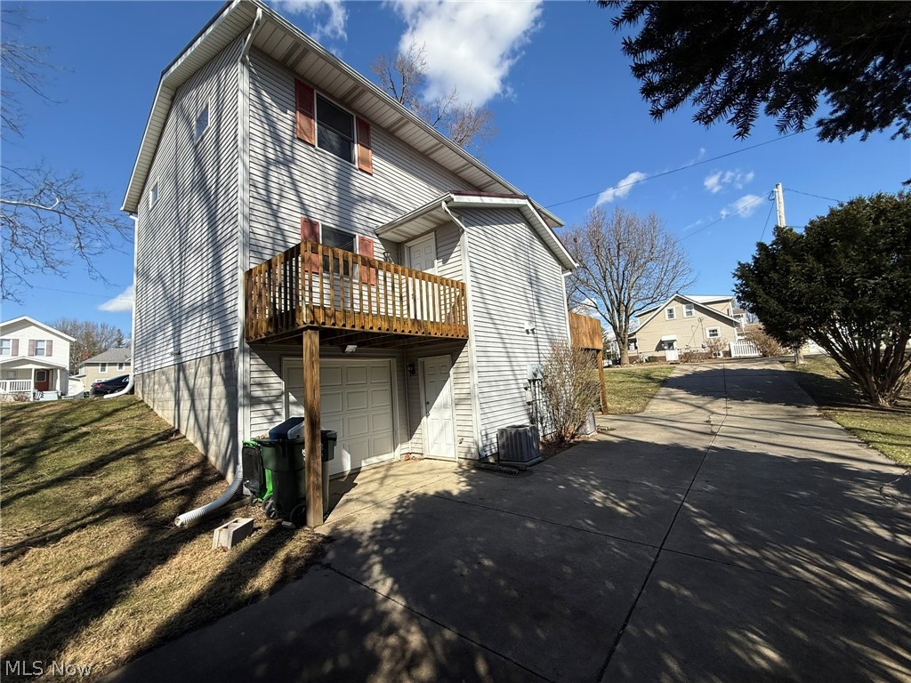604 Harger Street Dover, OH 44622 - Photo 22 of 25 Rear view of property featuring concrete driveway, an attached garage, and a yard